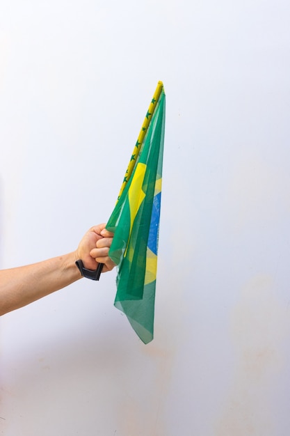 Sosteniendo la bandera de Brasil aislado sobre fondo blanco. Imagen de concepto de bandera y día de la independencia.