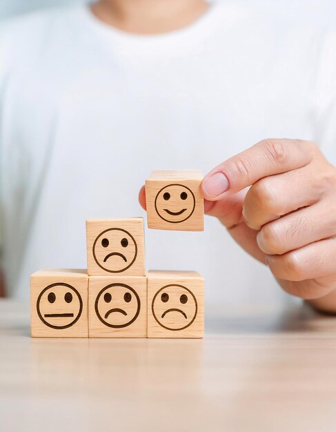 sosteniendo bloques faciales de emoción que representan varias expresiones como feliz triste enojado y neutro