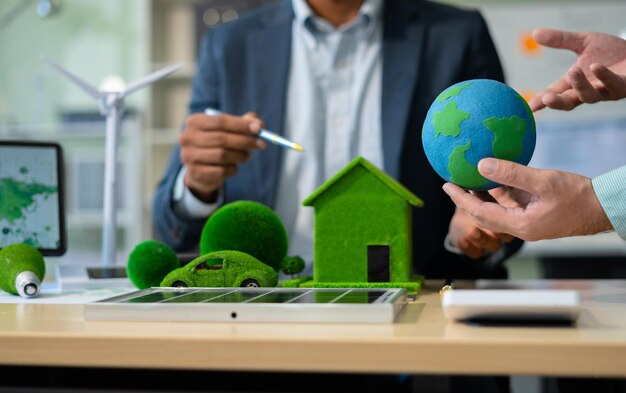 Sosteniendo una bombilla contra la naturaleza en una hoja verde con icono de fuente de energía para el concepto de ecología de desarrollo renovable y sostenible