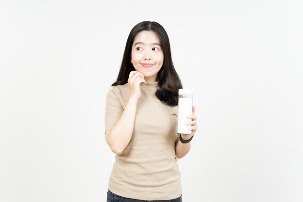 Sosteniendo la botella y mirar hacia otro lado de la hermosa mujer asiática aislado sobre fondo blanco.