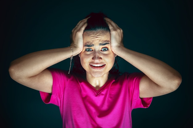 Sosteniendo la cabeza Retrato de joven mujer caucásica asustada y conmocionada loca aislada