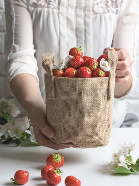 Sosteniendo la canasta llena con fresas