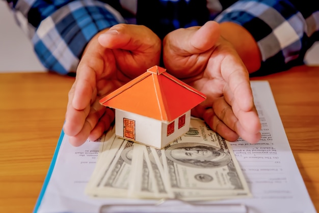 Foto sosteniendo la casa que representa la propiedad de la vivienda y el negocio inmobiliario.