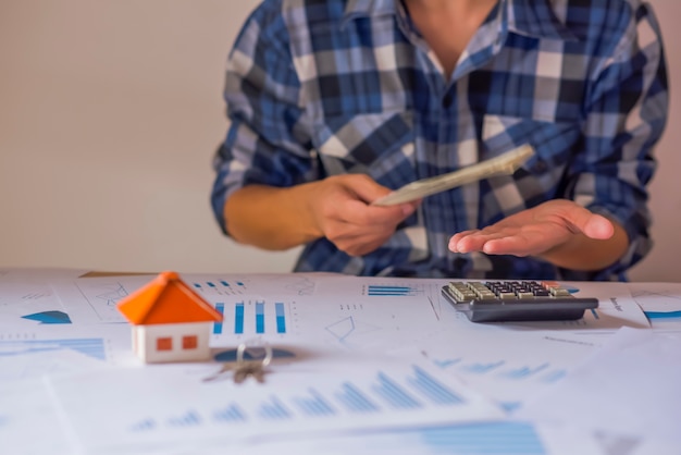 Foto sosteniendo la casa que representa la propiedad de la vivienda y el negocio inmobiliario.