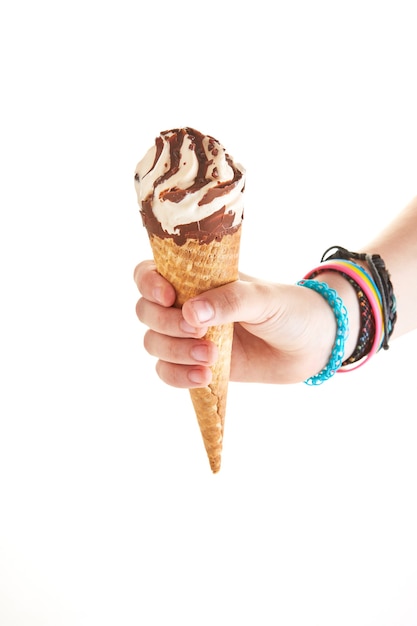 Sosteniendo helado con chocolate en cono en mano aislado sobre fondo blanco.