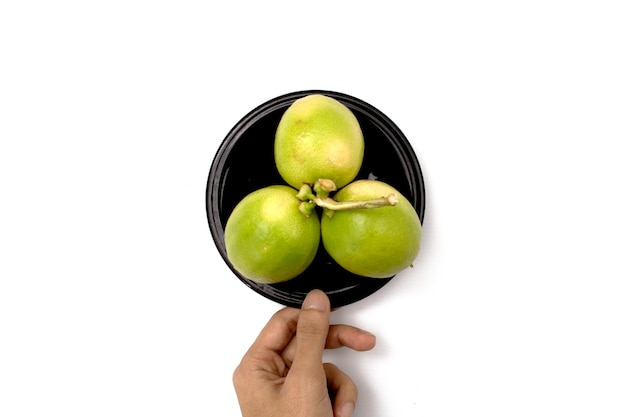 sosteniendo un limón en un plato sobre un fondo blanco