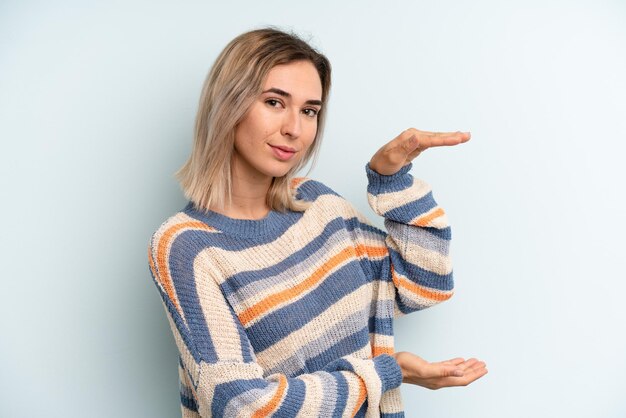 Sosteniendo un objeto con ambas manos en el espacio de copia lateral que muestra la oferta o publicidad de un objeto