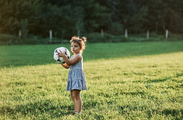 Sosteniendo la pelota. Adorable niño ama el fútbol y todo lo que está relacionado con él.