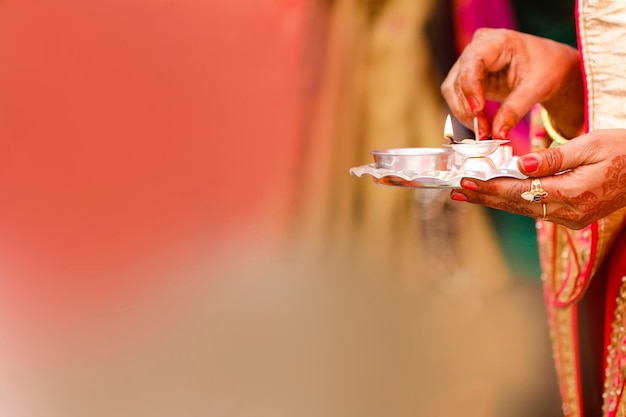 Sosteniendo puja thali y lámpara de aceite en la mano