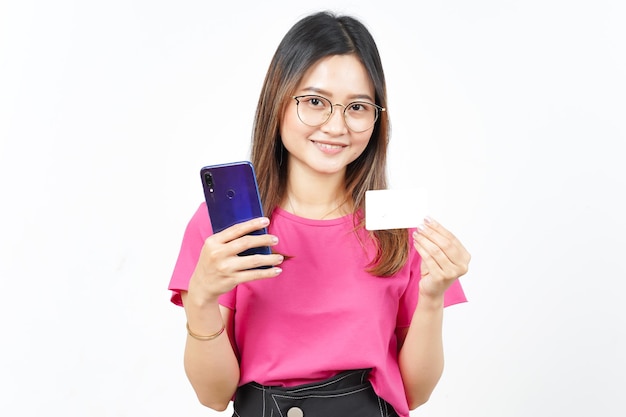 Sosteniendo teléfono inteligente y crédito en blanco o tarjeta bancaria de hermosa mujer asiática aislada en blanco