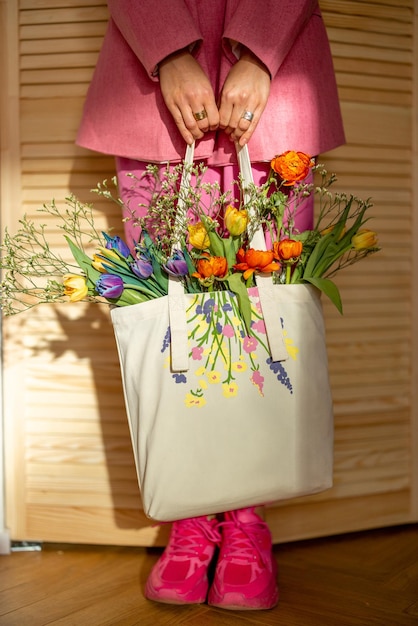 Sosteniendo totebag lleno de flores