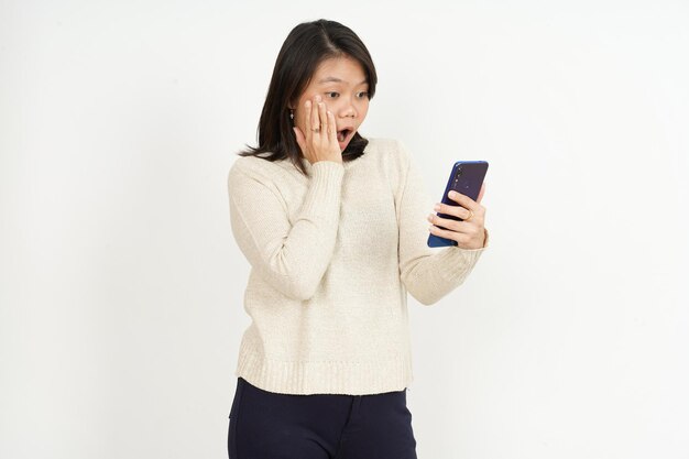 Sosteniendo y usando el teléfono inteligente de la hermosa mujer asiática aislada sobre fondo blanco