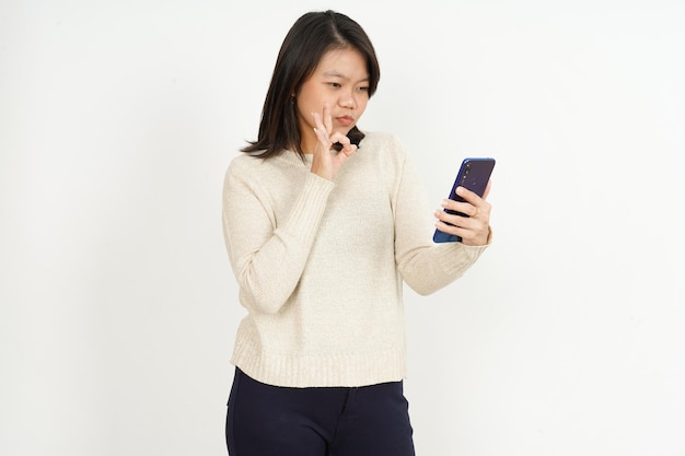 Sosteniendo y usando el teléfono inteligente de la hermosa mujer asiática aislada sobre fondo blanco