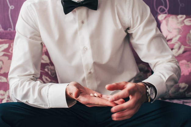 Sostiene dos anillos de boda en la mano