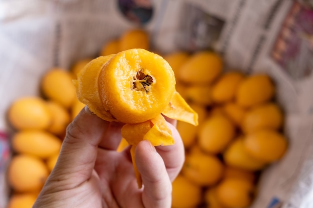 Sostuvo la fruta de níspero comido en su mano