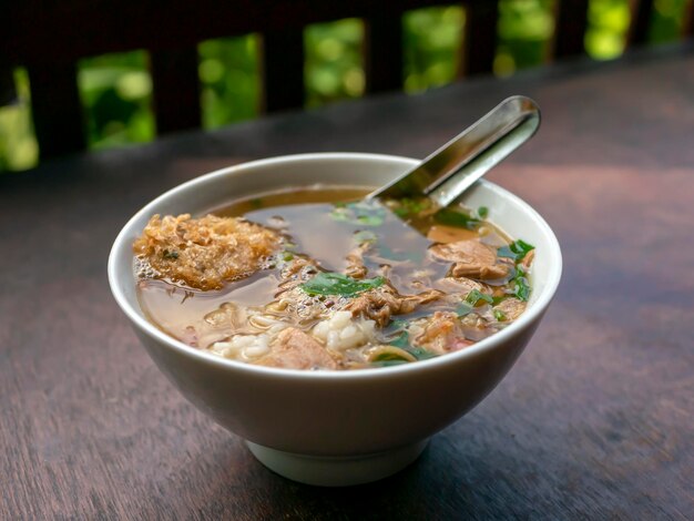 Soto Ayam eine traditionelle indonesische Hühnersuppe auf einem Holztisch