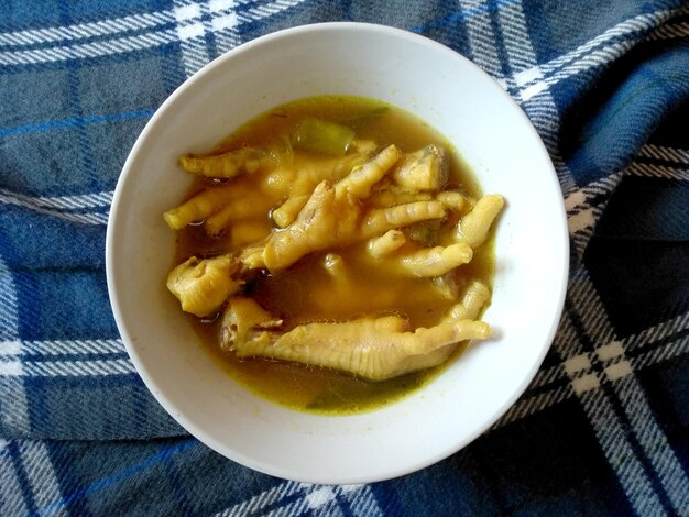 Soto Ceker Ayam Kuah Kuning ou Soto pés de galinha em uma tigela de comida culinária indonésia