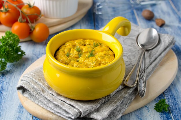 Soufflé de queso francés horneado con zanahorias y eneldo en molde blanco