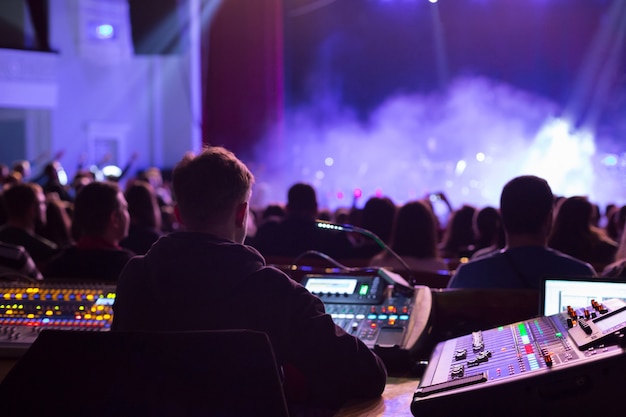 Soundman trabajando en la mesa de mezclas en la sala de conciertos