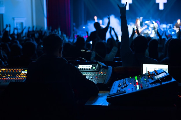 Soundman trabajando en la mesa de mezclas en la sala de conciertos