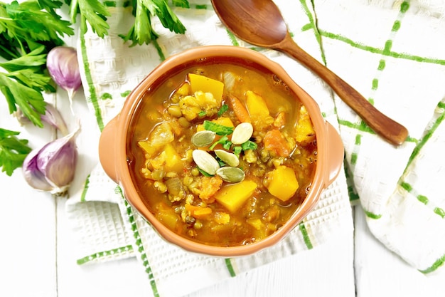 Soupcurry com abóbora e lentilhas em uma tigela em cima de uma tábua leve