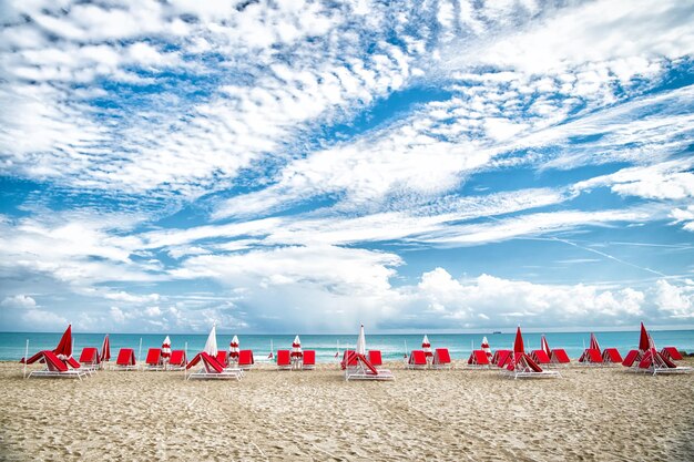 South Beach, Miami. playa de mar con hamacas y sombrillas sobre fondo natural en Miami, Estados Unidos. Vacaciones de verano en el paraíso. Concepto de tomar el sol y nadar. Recreación, relax y lounge