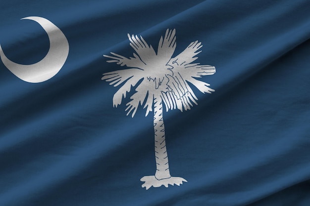 South carolina us-staatsflagge mit großen falten, die dicht unter dem studiolicht im innenbereich des büros wehen