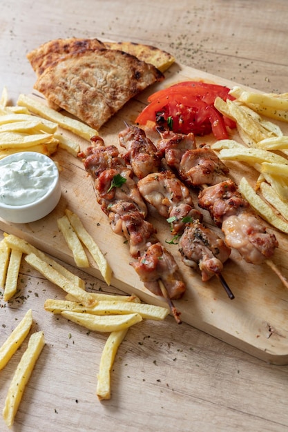 Foto souvlaki-gericht griechisches hähnchenfleisch essen gegrillte spieße und fladenbrot auf holztisch oben