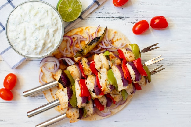 Souvlaki de pollo asado griego tradicional con salsa Tzatziki y pan de pita