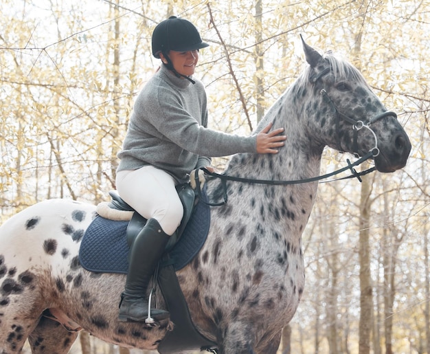 Soy un gavilán, trota el aire. Disparo de una mujer joven y atractiva montando con su caballo afuera.