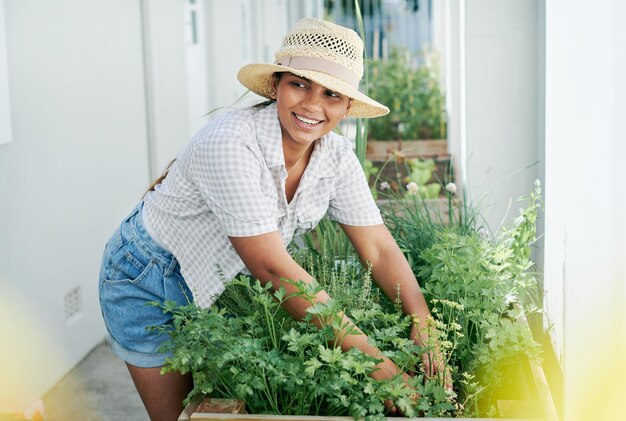 Soy un mini granjero cuando estoy en mi huerta Foto de una mujer joven y atractiva parada sola afuera y haciendo jardinería durante el día