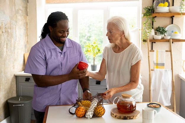 Foto sozialarbeiterin, die mit einer älteren frau essen macht