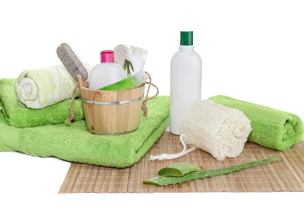 Spa bodegón artículos de higiene personal toallas verdes esponja natural y hojas de aloe en un primer plano de la mesa