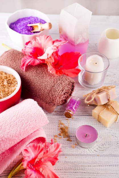 Spa conjunto com flor, vela, sabonete e sal de massagem em fundo de madeira