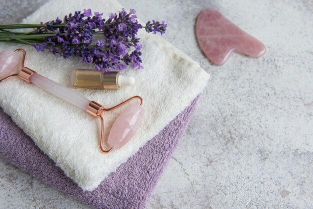 Spa de lavanda. Aceites esenciales, rodillo facial, toallas. Cosmético de hierbas naturales con flores de lavanda