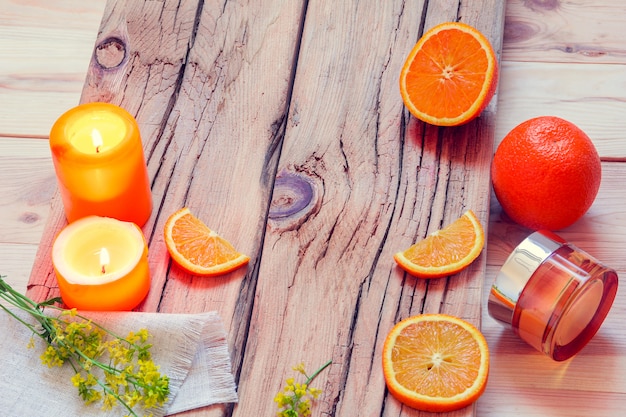 SPA con naranjas, velas, crema y flores.