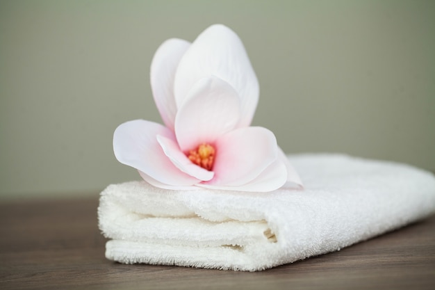 Spa Orchidee mit weichen Handtüchern auf Holztisch.