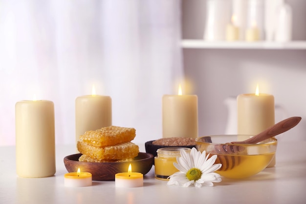 Spa-Set mit Honigbehandlungen und Kerzen auf weißem Tisch
