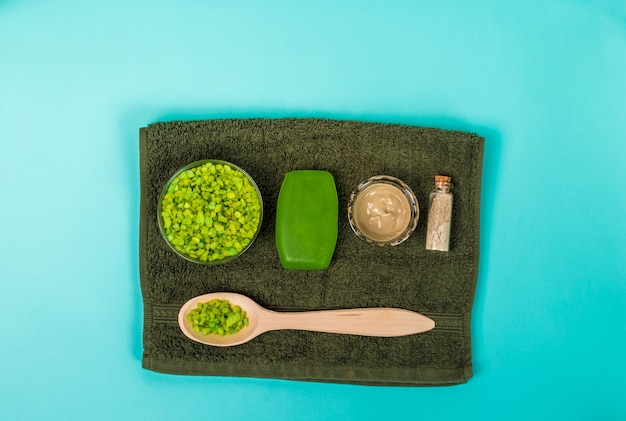 Spa-Set Seifenmaske Öl Meersalz und Handtuch auf blauem Hintergrund