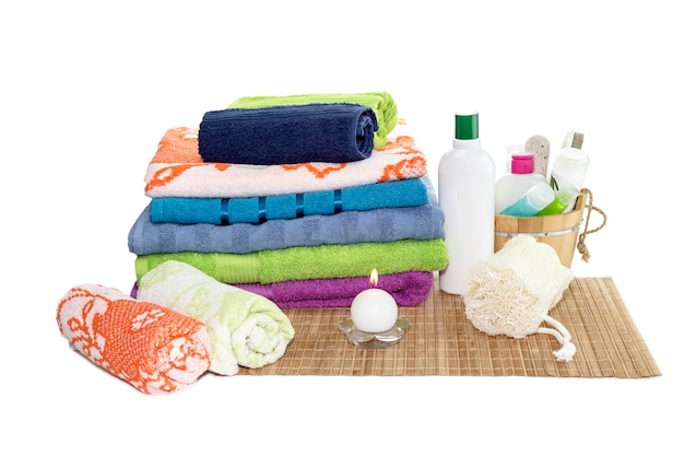 Spa-Stillleben Körperpflegeartikel Handtücher in verschiedenen Farben und Naturschwamm auf einem Tisch in der Nähe