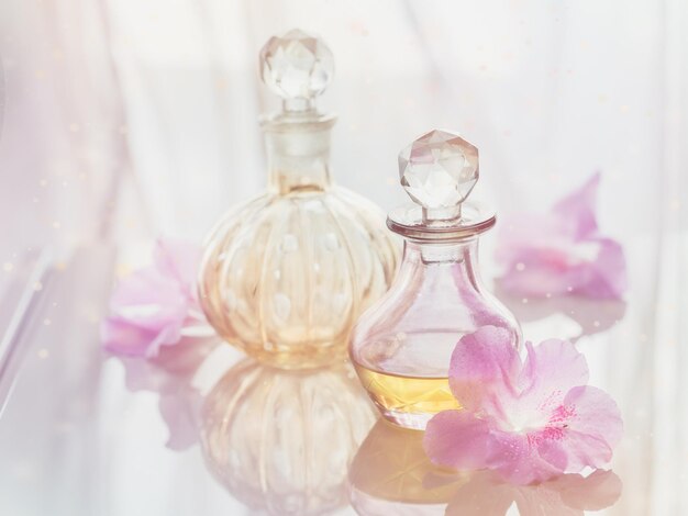 Spa-Stillleben mit Parfüm- und Aromaölflaschen, umgeben von Blumen