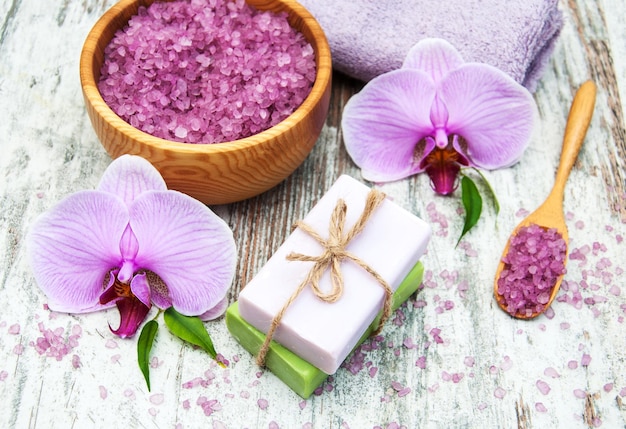 Spa- und Massageprodukte mit Orchideen auf einem alten hölzernen Hintergrund