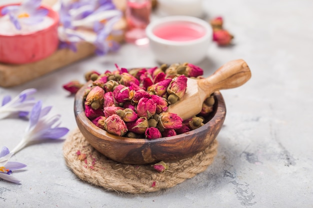 Spa- und wellnesskonzept mit trockenen rosen, rosa öl und milch auf betonhintergrund.