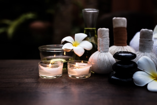 Foto spa vida com orquídea branca, sal marinho, óleo de banho e vela no chão de madeira, relaxante con