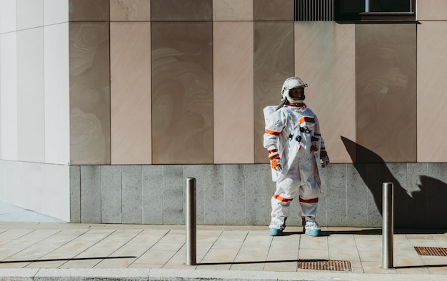 Spaceman em uma estação futurista. astronauta com traje espacial caminhando em área urbana