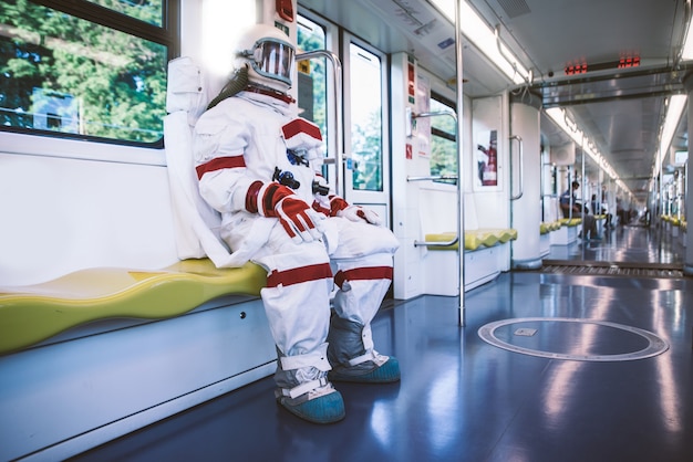 Spaceman em uma estação futurista. homem com traje espacial saindo para o trabalho e pegando o trem