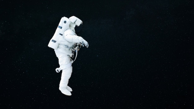Spaceman vuela en el espacio abierto sobre un fondo estrellado oscuro. El astronauta comienza una misión. Cosmos y humanos