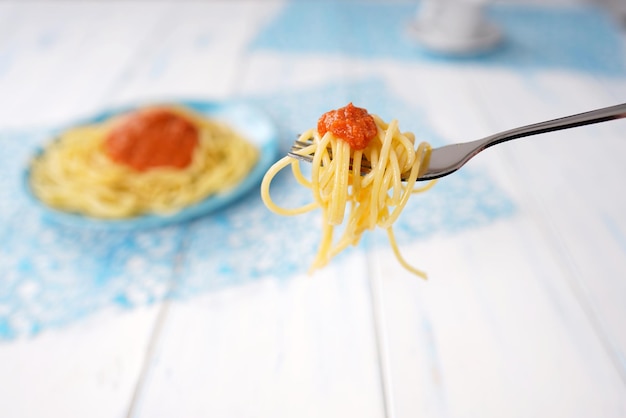 Foto spaghetti auf einer gabel mit tomatensauce.