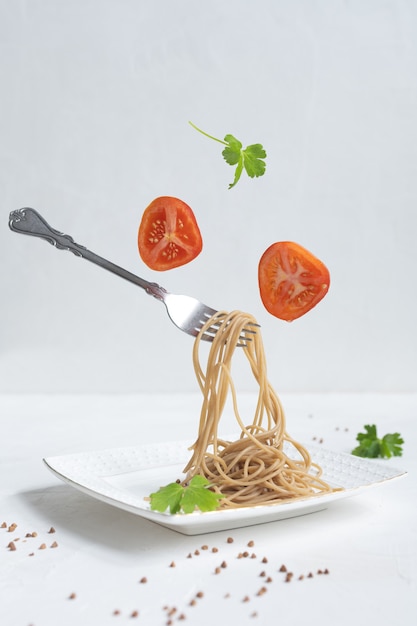 Spaghetti aus Buchweizen auf einem weißen Tisch.