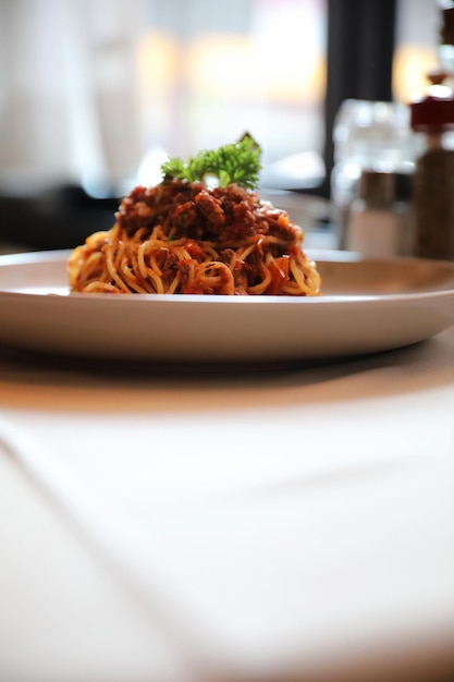 Spaghetti Bolognese mit Hackfleisch und Tomatensauce, garniert mit Parmesankäse und Basilikum, italienisches Essen